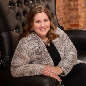 Managing director Amanda Haddaway sitting in a large leather chair smiling at the camera